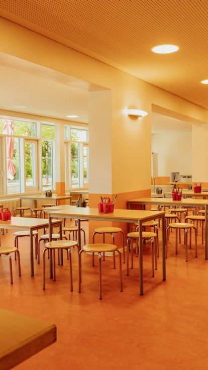 Unsere Mensa hat eine wunderschöne Terrasse vor der Tür und innen ist sie ein Multifunktionsraum. Hier wird gegessen, gebastelt, getanzt und mit digitalien Medien gearbeitet. Wir haben so ein Glück, dass wir so einen schönen Multifunktionsraum haben.